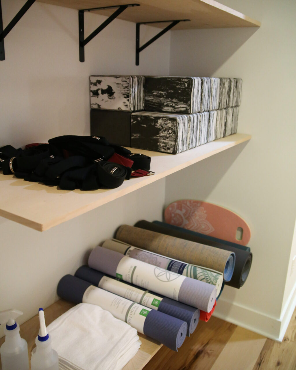 A photo of yoga mats, blocks, straps, and other items that students can borrow for class